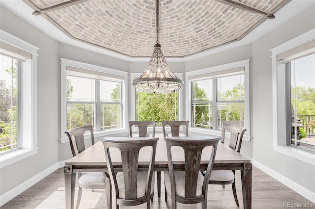 dining area with light hardwood / wood-style floors and a chandelier