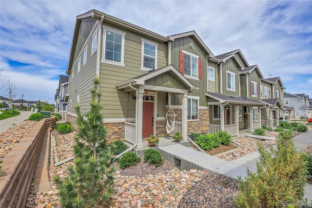 16818 E 119th Ave Unit A, Commerce City, CO 80022 - view of front of property featuring a residential view, board and batten siding, stone siding, and a porch
