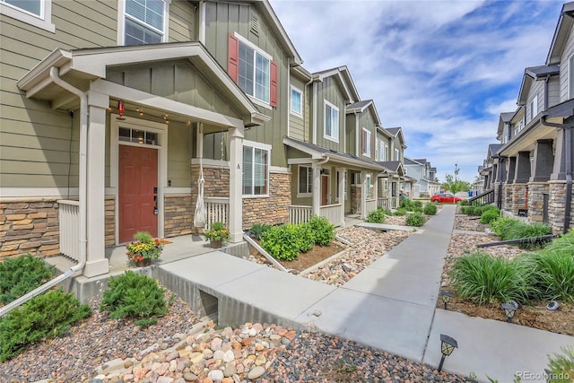 16818 E 119th Ave Unit A, Commerce City, CO 80022 - entrance to property featuring board and batten siding, a residential view, stone siding, and covered porch