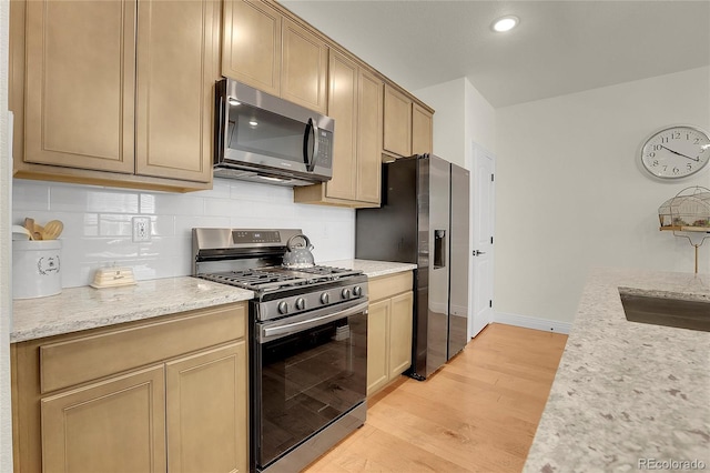 16818 E 119th Ave Unit A, Commerce City, CO 80022 - kitchen with stainless steel appliances, light wood finished floors, tasteful backsplash, baseboards, and a sink