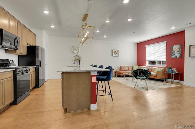 16818 E 119th Ave Unit A, Commerce City, CO 80022 - kitchen with stainless steel appliances, a sink, recessed lighting, a kitchen bar, and a kitchen island with sink