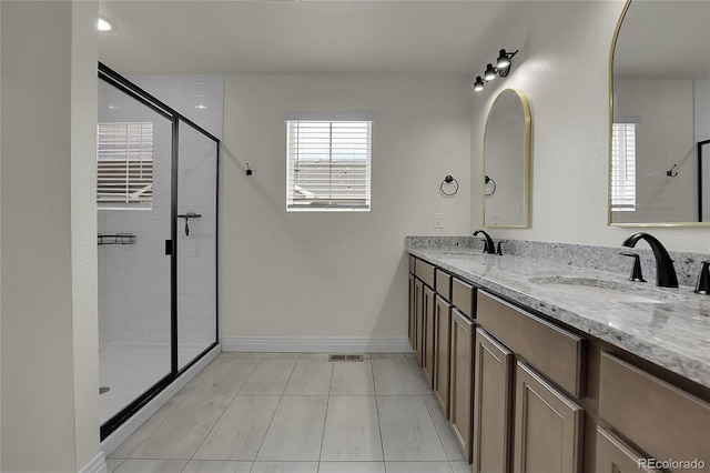 16818 E 119th Ave Unit A, Commerce City, CO 80022 - bathroom with tile patterned floors, a stall shower, double vanity, and baseboards