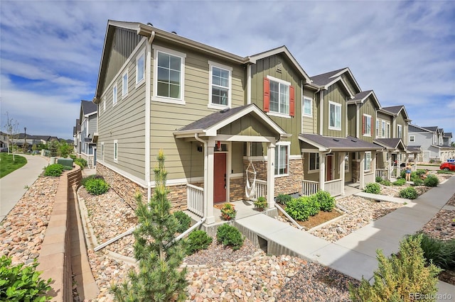 16818 E 119th Ave Unit A, Commerce City, CO 80022 - multi unit property featuring board and batten siding, a residential view, a porch, and stone siding