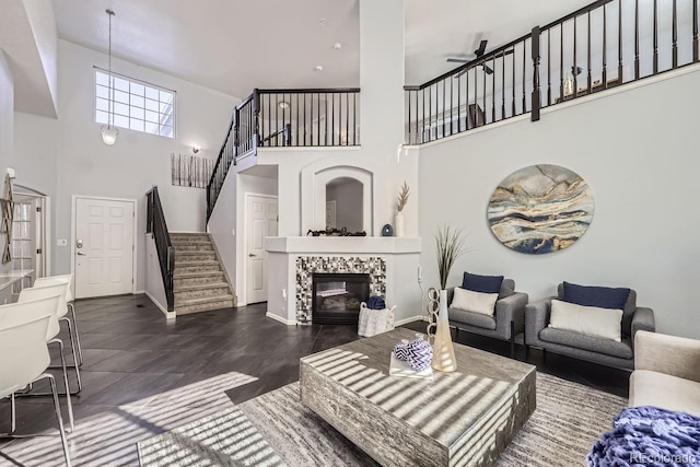 living room featuring a towering ceiling and a tile fireplace