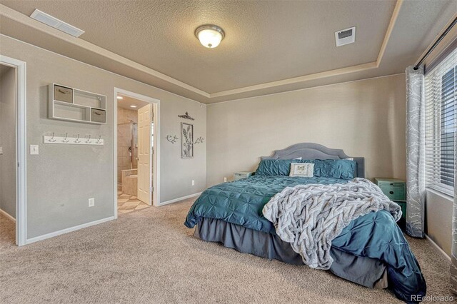 7963 Bonfire Trl, Fountain, CO 80817 - bedroom featuring carpet floors, a textured ceiling, a tray ceiling, baseboards, and connected bathroom