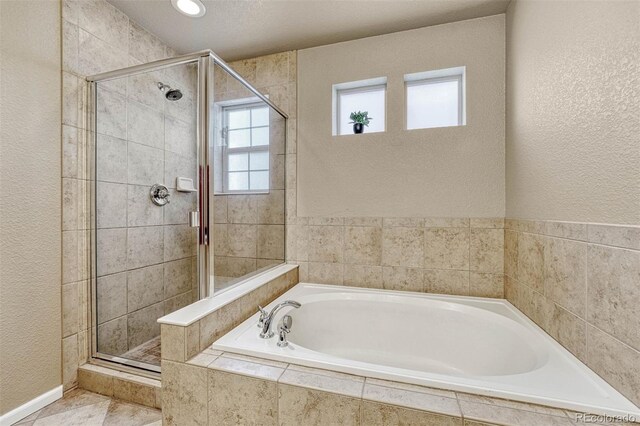 7963 Bonfire Trl, Fountain, CO 80817 - full bath with a stall shower, a textured wall, and a bath