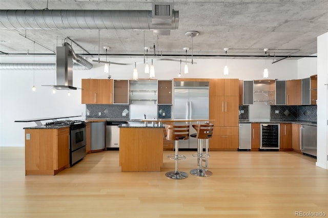 kitchen with light wood-style floors, stainless steel appliances, wine cooler, and extractor fan