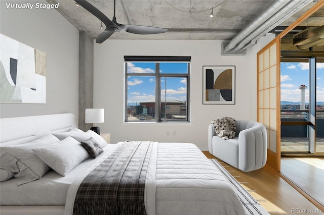 bedroom with access to outside, a ceiling fan, and wood finished floors