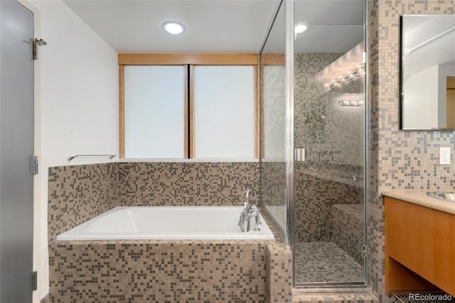 bathroom featuring a stall shower, a bath, and vanity