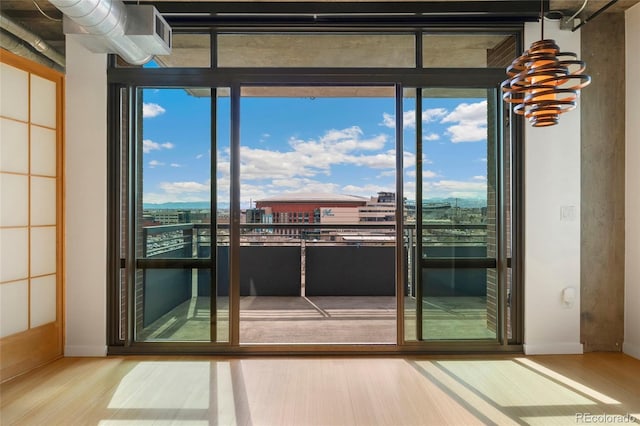 doorway with a view of city and wood finished floors