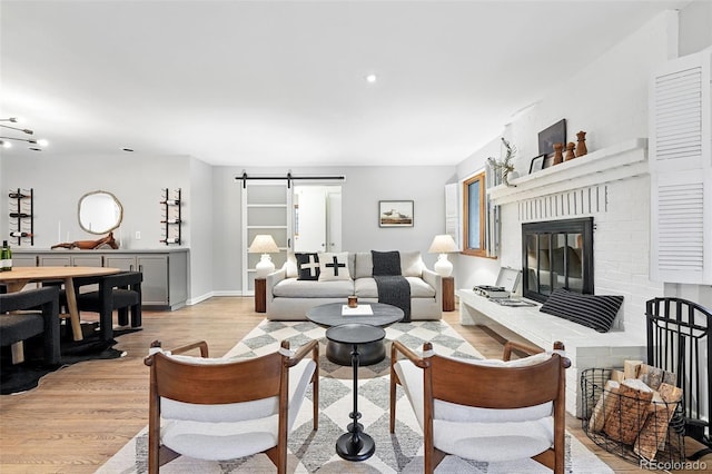 11 S Albion St, Denver, CO 80246 - living area with a barn door, light wood-type flooring, a brick fireplace, baseboards, and recessed lighting