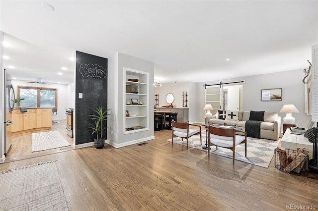 11 S Albion St, Denver, CO 80246 - living room with a barn door, light wood-style flooring, built in features, a ceiling fan, and baseboards