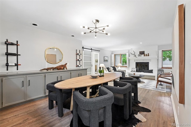 11 S Albion St, Denver, CO 80246 - dining room with a barn door, light wood-type flooring, a glass covered fireplace, and a chandelier