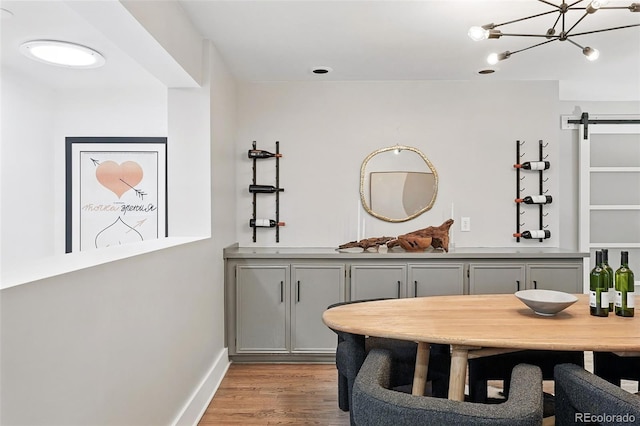 11 S Albion St, Denver, CO 80246 - dining area with light wood-style flooring, a barn door, a chandelier, and baseboards