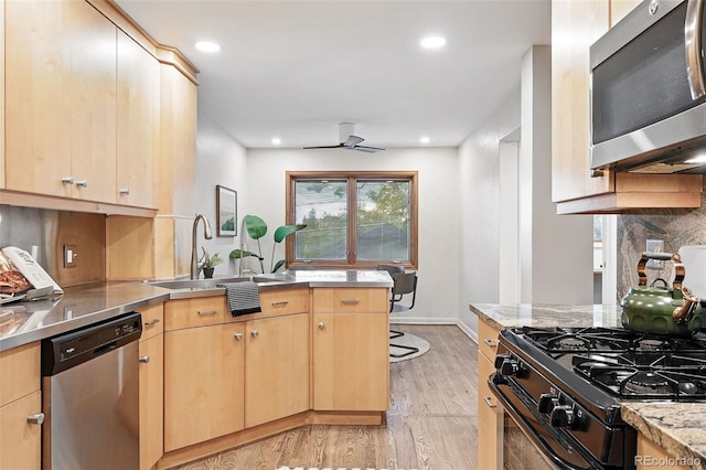 11 S Albion St, Denver, CO 80246 - kitchen featuring stainless steel countertops, appliances with stainless steel finishes, light brown cabinetry, a sink, and light wood finished floors
