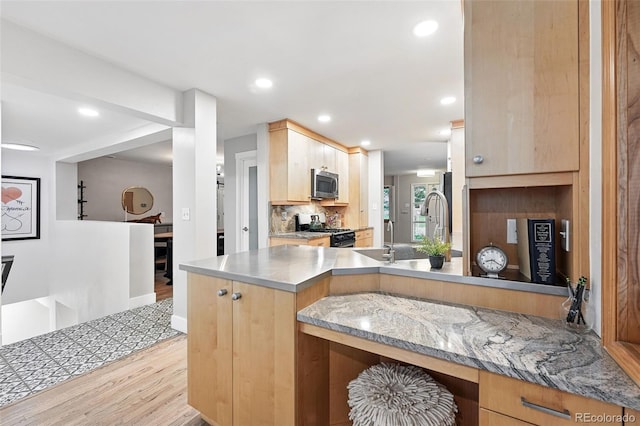11 S Albion St, Denver, CO 80246 - kitchen featuring stainless steel appliances, stainless steel counters, light wood-style floors, light brown cabinetry, and decorative backsplash