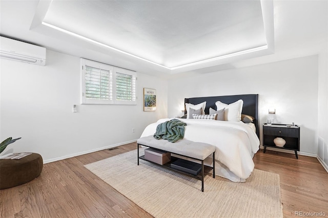 11 S Albion St, Denver, CO 80246 - bedroom featuring a tray ceiling, an AC wall unit, wood finished floors, and baseboards
