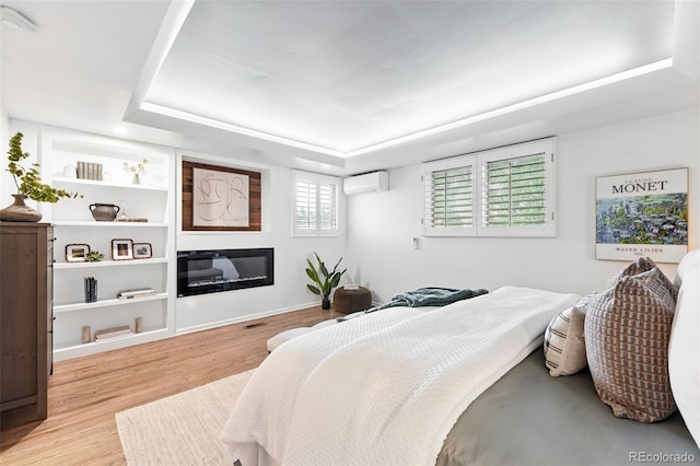 11 S Albion St, Denver, CO 80246 - bedroom with a wall unit AC, a tray ceiling, wood finished floors, and a glass covered fireplace