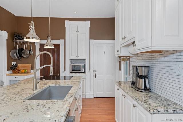 1154 N Clarkson St, Denver, CO 80218 - kitchen featuring tasteful backsplash, white cabinetry, and light wood-style floors