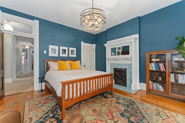 1154 N Clarkson St, Denver, CO 80218 - bedroom with hardwood / wood-style floors, a chandelier, and a fireplace