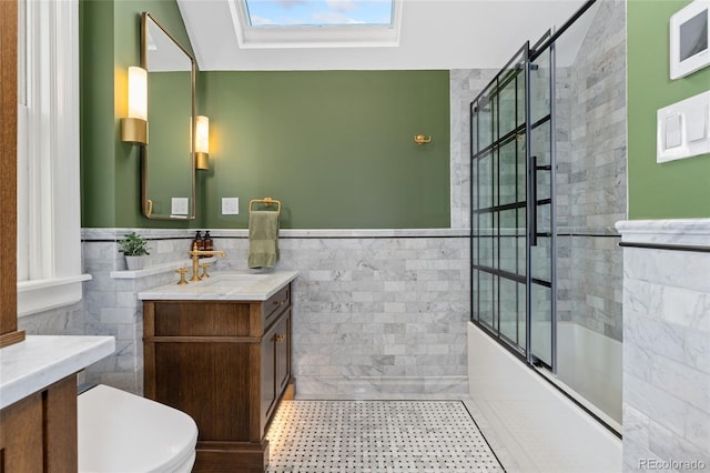 1154 N Clarkson St, Denver, CO 80218 - full bath featuring tile walls, vanity, a skylight, bath / shower combo with glass door, and a wainscoted wall