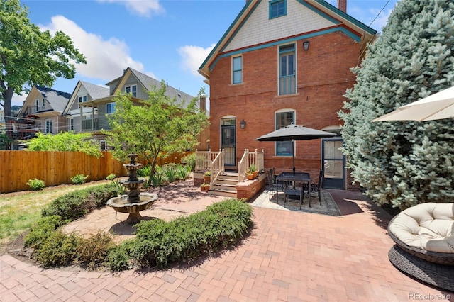 1154 N Clarkson St, Denver, CO 80218 - rear view of property featuring a patio and brick siding