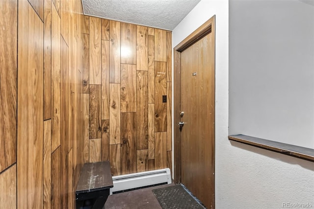 675 Straight Creek Dr Unit 301, Dillon, CO 80435 - entryway featuring a baseboard radiator, a textured ceiling, and wood walls