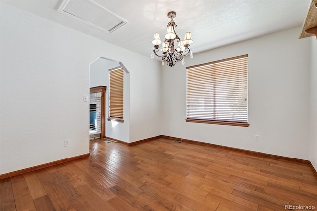 13457 Glen Cir, Broomfield, CO 80020 - spare room with hardwood / wood-style floors, arched walkways, and a chandelier