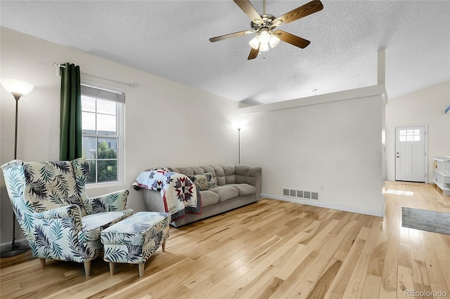 2659 S Halifax St, Aurora, CO 80013 - living room featuring a textured ceiling, light wood finished floors, a ceiling fan, and lofted ceiling