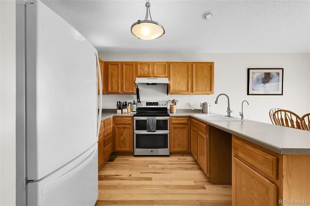 2659 S Halifax St, Aurora, CO 80013 - kitchen featuring freestanding refrigerator, range with two ovens, under cabinet range hood, a peninsula, and light wood finished floors