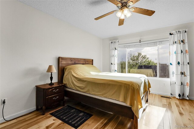 2659 S Halifax St, Aurora, CO 80013 - bedroom with light wood-style floors, a textured ceiling, and a ceiling fan