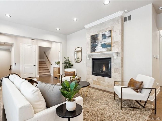 living room with a tile fireplace and hardwood / wood-style floors