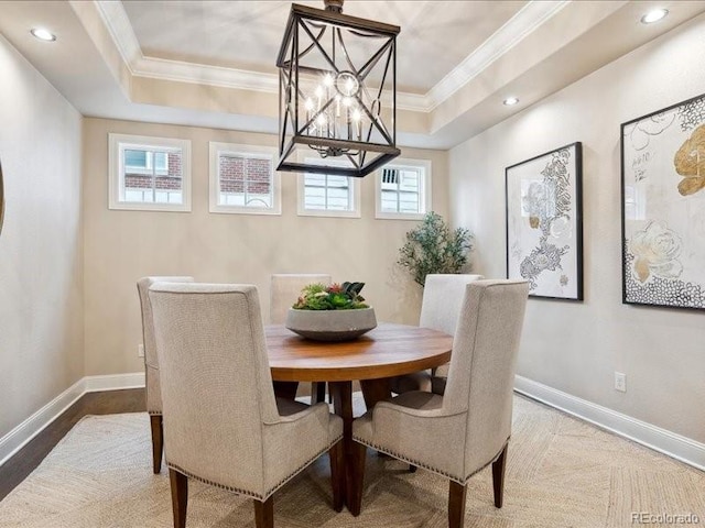 dining room featuring ornamental molding, a raised ceiling, and a notable chandelier