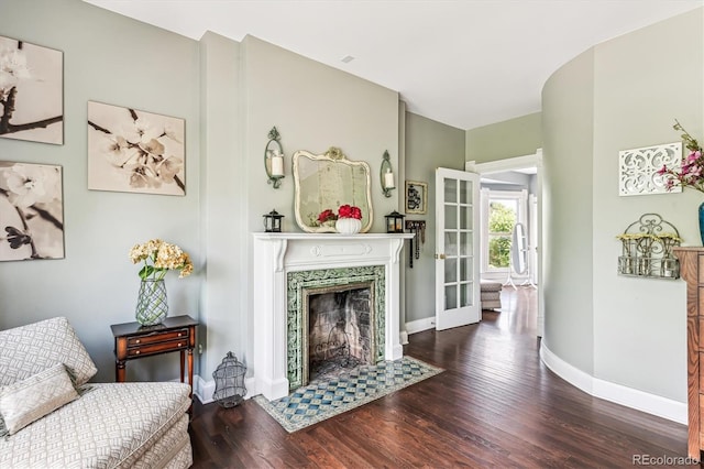 sitting room with dark hardwood / wood-style floors and a premium fireplace