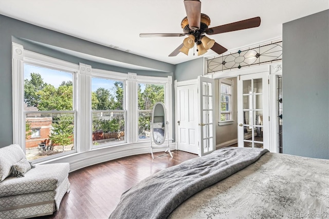 bedroom with ceiling fan, dark hardwood / wood-style flooring, a closet, and french doors