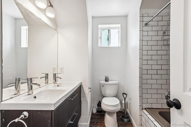 full bathroom with toilet, vanity, and tiled shower / bath