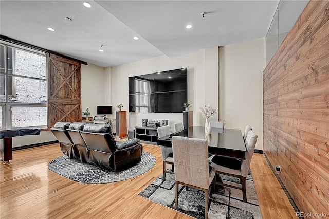 dining area with light hardwood / wood-style flooring and a barn door