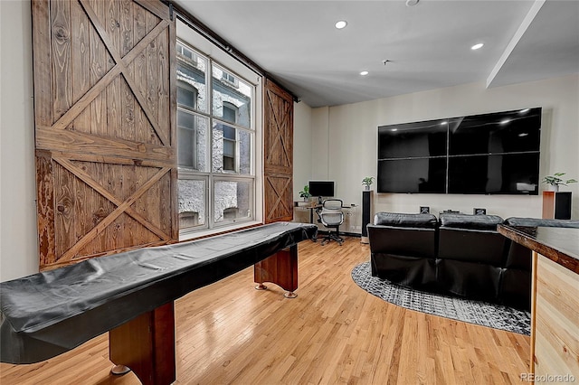 office space featuring wood-type flooring, pool table, and a barn door