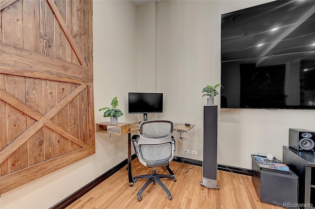 office space featuring a barn door and hardwood / wood-style floors