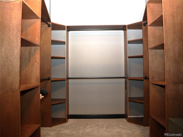 walk in closet featuring light carpet