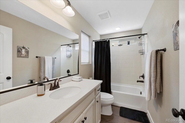 full bathroom with hardwood / wood-style flooring, vanity, shower / bath combo, and toilet