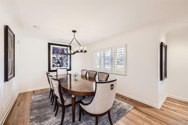 dining room featuring wood-type flooring and a chandelier