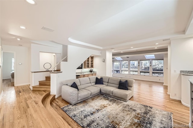 living room with light hardwood / wood-style floors and sink