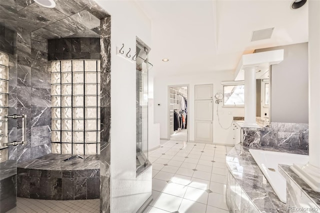 interior space with separate shower and tub, ornate columns, and tile patterned flooring