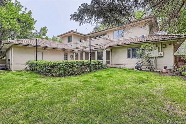 2 Elm St, Denver, CO 80220 - rear view of property featuring a balcony, stucco siding, a tiled roof, and a lawn