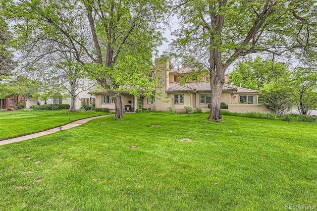 2 Elm St, Denver, CO 80220 - view of front of house with a chimney, stucco siding, a front lawn, and a tiled roof