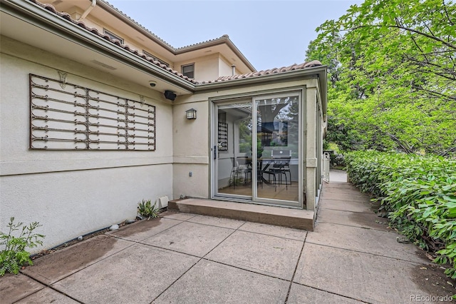 2 Elm St, Denver, CO 80220 - entrance to property with stucco siding, a patio, and a tiled roof