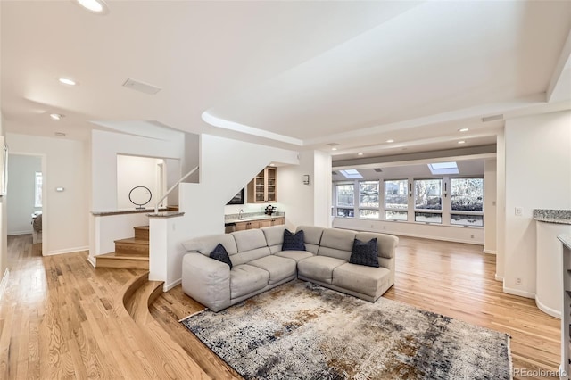 2 Elm St, Denver, CO 80220 - living area featuring stairs, recessed lighting, light wood-type flooring, a raised ceiling, and baseboards