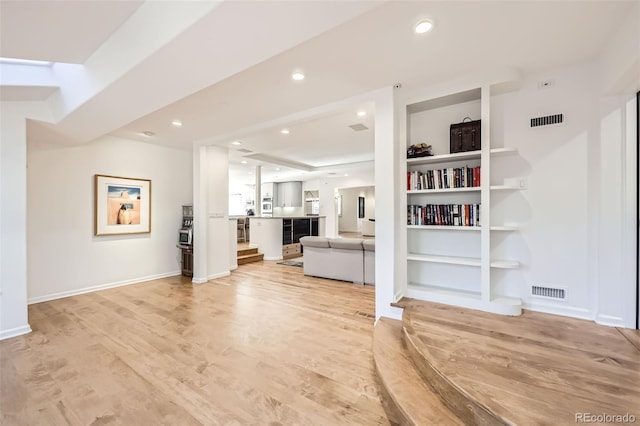 2 Elm St, Denver, CO 80220 - unfurnished living room featuring light wood-style floors, baseboards, recessed lighting, and built in shelves