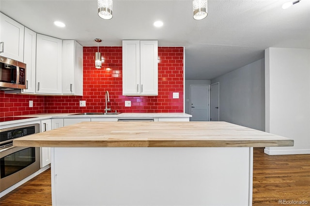 6948 W 70th Ave, Arvada, CO 80003 - kitchen featuring a sink, white cabinetry, appliances with stainless steel finishes, and butcher block counters